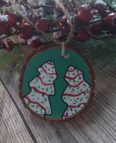 a wooden ornament with two dogs on it hanging from a christmas tree branch