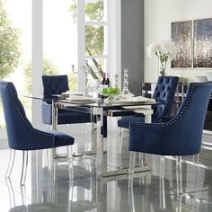 a glass dining table with blue chairs around it