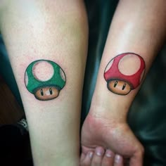 two people with matching tattoos on their arms, both have mario and luigi mushroom faces