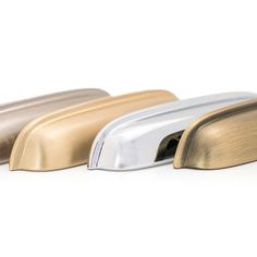 three metallic and gold door handles on a white background