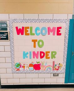 a welcome to kinder school sign in front of a wall with the words welcome to kinder on it