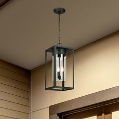 an outdoor light hanging from the ceiling in front of a door with two lights on it