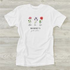 a white t - shirt with flowers and the words, mom's garden of love