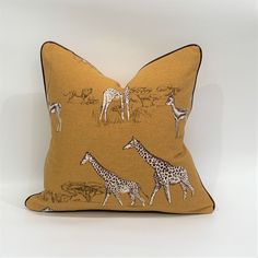 a yellow pillow with giraffes and zebras on the front is shown