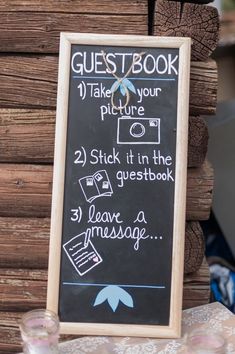 a chalkboard sign that says guest book and has instructions to take pictures on it