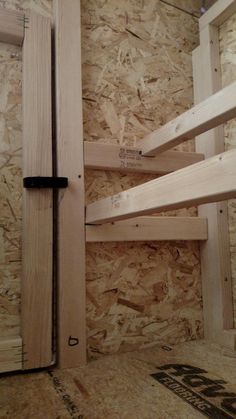 the inside of a room with wooden shelves and plywood boards on the wall behind it