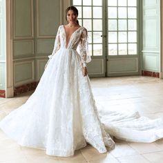 a woman in a white wedding dress standing on the floor with her arms behind her back