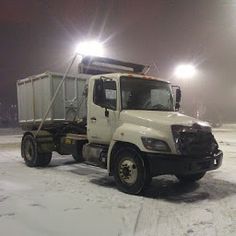 a white truck parked in the snow at night