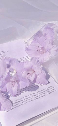 some flowers are laying on top of an open book