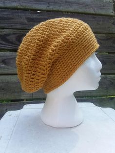 a white mannequin head wearing a yellow knitted hat