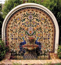 an ornate fountain surrounded by greenery and flowers