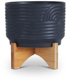 a large black pot sitting on top of a wooden stand