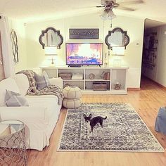 a living room filled with furniture and a flat screen tv mounted on a wall above a fireplace