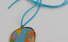 a necklace with a map on it and a blue cord hanging from the front end