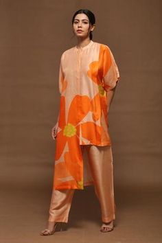 Burning orange kurta with floral printed motifs and asymmetrical hem. Comes with striped pants.
Component: 2
Pattern: Printed
Type Of Work: Floral Print
Neckline: Band
Sleeve Type: Flared
Fabric: Dupion Silk
Color: Orange
Other Details: 
Flared sleeves
Asymmetrical hem
Striped kurta
Closure: Concealed button front
Occasion: Resort - Aza Fashions Kaftan Kurta, Asymmetric Kurta, Textile Print, Dupion Silk, Pants Fit, Indian Fashion Designers, Kurta With Pants, Matching Pants, Designer Gowns