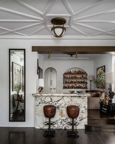 a living room filled with furniture and a bar in the middle of it's walls