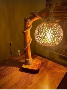 a wooden table topped with a lamp and a light fixture on top of it next to a window