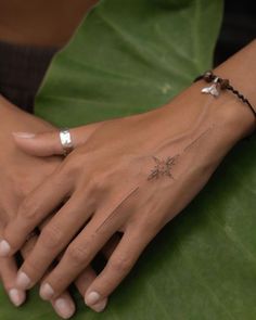 a woman's hand with a small star tattoo on it