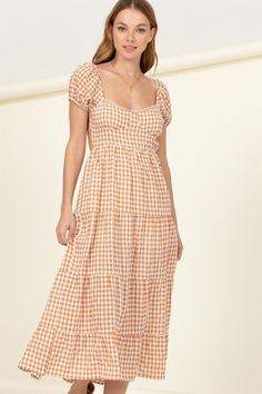 The Somewhere to Go Tie-Back Gingham Print Maxi Dress is the epitome of summer charm. Its design includes a sweetheart neckline, short sleeves, and a bustier-inspired bodice that ties at the back, adding a touch of romance and allure to the dress. The high waist beautifully defines your silhouette and flows into a full maxi skirt that cascades down to a tiered hem. The gingham print adds a classic and timeless element to this dress, making it a versatile choice for various occasions. Imported. D Short Sleeve Gingham Dress With Smocked Bodice, Gingham Short Sleeve Dress With Smocked Bodice, Gingham Dress With Smocked Bodice And Short Sleeves, Gingham Dress With Short Sleeves For Garden Party, Gingham Short Sleeve Dresses For Brunch, Full Maxi Skirt, Printed Long Dresses, Maxi Dress Online, Boho Print