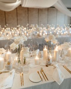 the table is set with white flowers and candles for an elegant wedding reception or special event