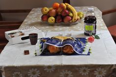 a table topped with fruit and condiments on top of a white table cloth