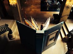 an open book sitting on top of a table next to a stair case filled with books