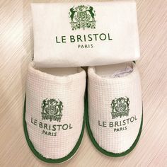 two pairs of white and green slippers with the label le bristol paris on them