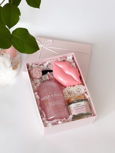 a pink gift box with soap, body lotion and flowers