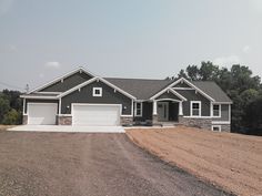 a large gray house with two garages on the front and one attached to it