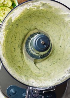 a food processor filled with green sauce and vegetables