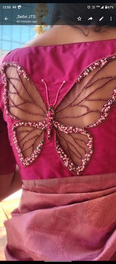 the back of a woman's pink dress with a butterfly appliqued on it