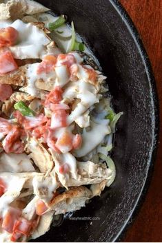 a black bowl filled with food on top of a wooden table