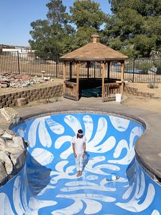 a man standing in the middle of a pool with blue and white designs on it