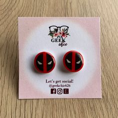 This listing is for one pair of Deadpool Stud Earrings.  These Unique, Light Weight, Stud Earrings perfect for those that love the Merc with the Mouth, Deadpool!  The earring is approximately 5/8" wide and 5/8" tall.  Made from a lightweight acrylic plastic, covered with a resin coating, and have a stainless steel stud backing.   ♥ Please note each pair is handmade and may vary slightly from the pair in the photo ♥ Deadpool Earrings, Dead Pool, Small Stud Earrings, Resin Coating, Small Earrings Studs, Acrylic Plastic, Geek Chic, Gothic Jewelry, Super Hero