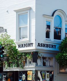 the front of a clothing store with trees growing out of it's window boxes