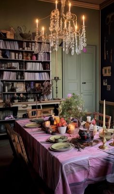 a dining room table is set with plates and candles