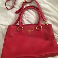 Beautiful Red Authentic Prada Vitello Daino Leather Tote Handbag. In Perfect Condition, Was A Gift That Was Never Used. Inner Zip Pocket And Side Pocket. Can Be Used As A Handbag Or Additional Shoulder Strap Can Be Attached And Adjusted. Information Tag, Protective Bag, And Certificate Of Authenticity. Length - 13.5 " Height- 9.5 " Width- 7 " Make An Offer! Luxury Red Shoulder Bag With Handles, Luxury Red Bag With Gold-tone Hardware, Luxury Red Bag With Handle Drop, Designer Red Satchel With Double Handle, Designer Red Satchel With Detachable Handle, Designer Red Bags With Gold-tone Hardware, Luxury Red Satchel With Handles, Red Formal Bag With Gold-tone Hardware, Red Shoulder Bag With Handle Drop For Formal Occasions