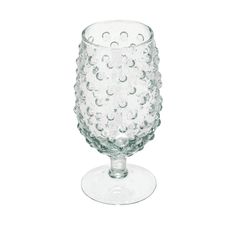 a clear glass with lots of bubbles on the rim and bottom, sitting on a white surface