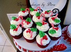 cupcakes with white frosting and candy canes are on a cake plate