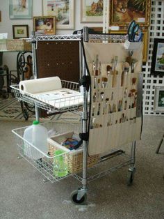 a shopping cart with lots of craft supplies on it in a room filled with pictures