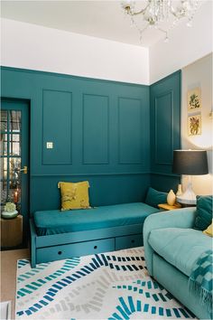 a living room with green walls and blue couches