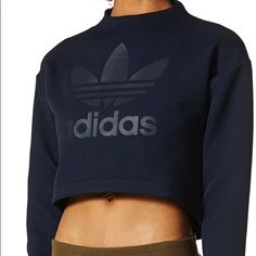 This Versatile Women's Sweatshirt Has A Cropped Cut And Extra-Long Cuffs For An Updated, Urban Silhouette. Made From A Thick Hexagon-Textured Jacquard, It Features A High Neck And Droptail Hem. Finished With A Side Zip On The Neck And Large Trefoil Logo Across The Chest. 100% Polyester Jacquard Rubber-Print Trefoil Logo On Front Ribbed Cuffs Cropped Length With Droptail Hem Zip On Shoulder Adidas Tops With Ribbed Cuffs For Streetwear, Navy Adidas Sporty Top, Adidas Navy Sporty Tops, Casual Navy Adidas Top, Navy Sporty Adidas Tops, Sporty Navy Adidas Tops, Casual Adidas Tops With Ribbed Cuffs, Blue Adidas Long Sleeve Tops, Adidas Blue Long Sleeve Tops