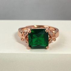 Rose gold plated faux emerald ring, this accessory adds a classic and sparkly touch to your style. The charming rose gold plated ring has cute butterfly and emerald crystal, the color of the birthstone that represents May, a thoughtful detail for this wonderful gift. Material: Cubic Zirconia/Rose Gold Plated/Copper Size: Adjustable ring size 6-9 by yourself, just open and close Stone Size: 9mm x 9mm Rose Gold Emerald Promise Ring, Rose Gold Emerald Rings As Gift, Rose Gold Emerald Ring As A Gift, Rose Gold Emerald Open Ring Gift, Smaragd Ring, Emerald Crystal, Cute Butterfly, Emerald Ring, Adjustable Ring