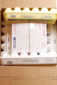 an open cardboard box with several eggs in it and one egg carton on the side