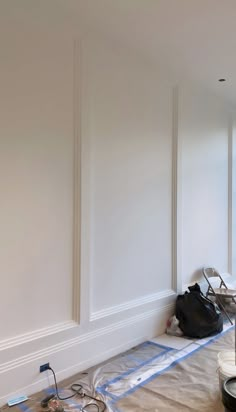 a room that has been painted white and is being worked on by the wall painters