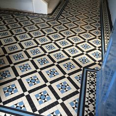 a black and white tiled floor with blue trim