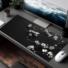 a desk with a computer, keyboard and flowers on it