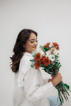 a woman sitting down holding a bouquet of flowers