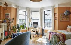 a bedroom with orange walls and furniture in the corner, along with a bike mounted to the wall