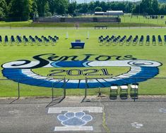 an empty field with benches and chairs in the background that says senior's 2012